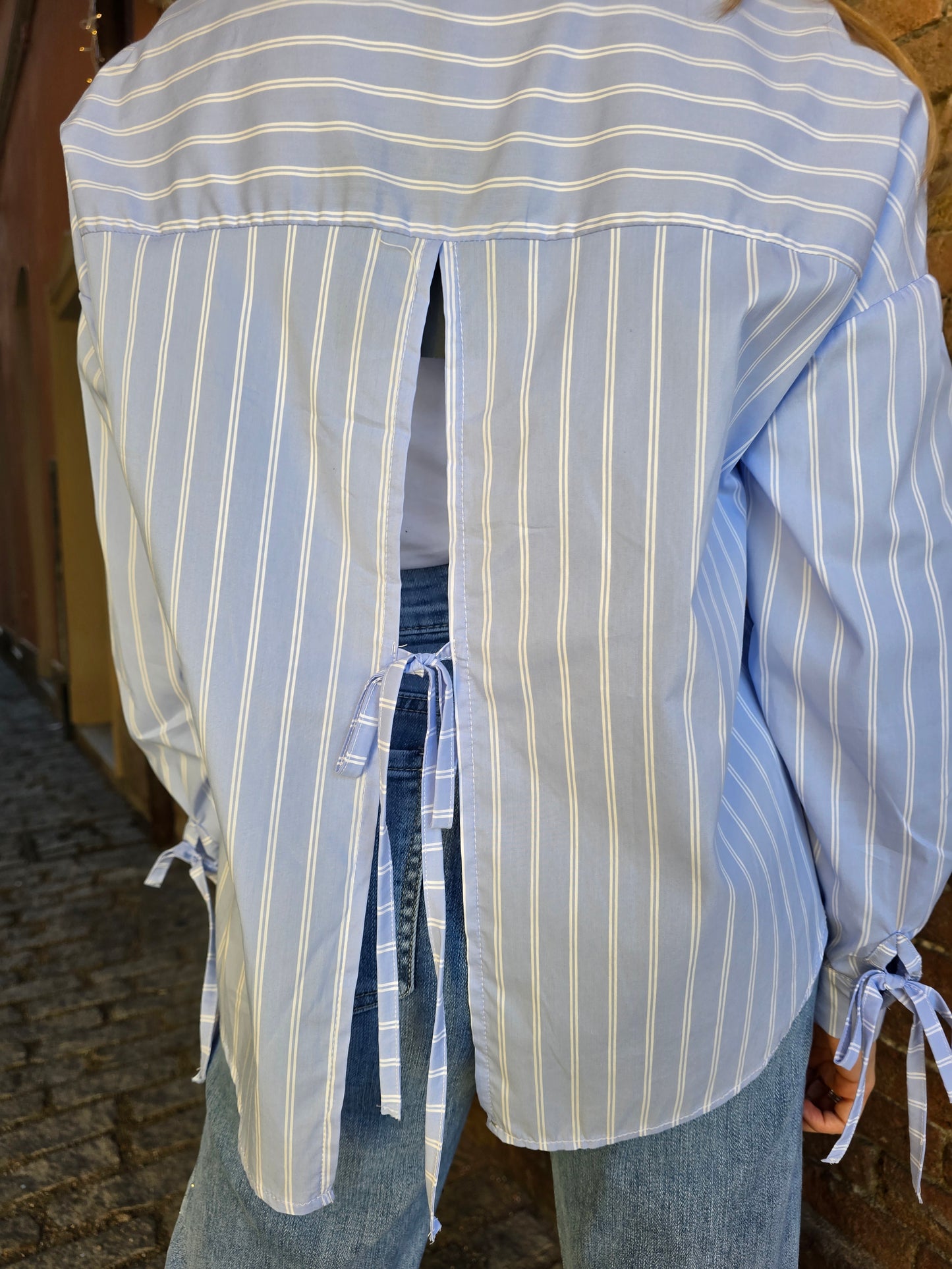 Camicia aperta sul retro azzurra a righe bianche